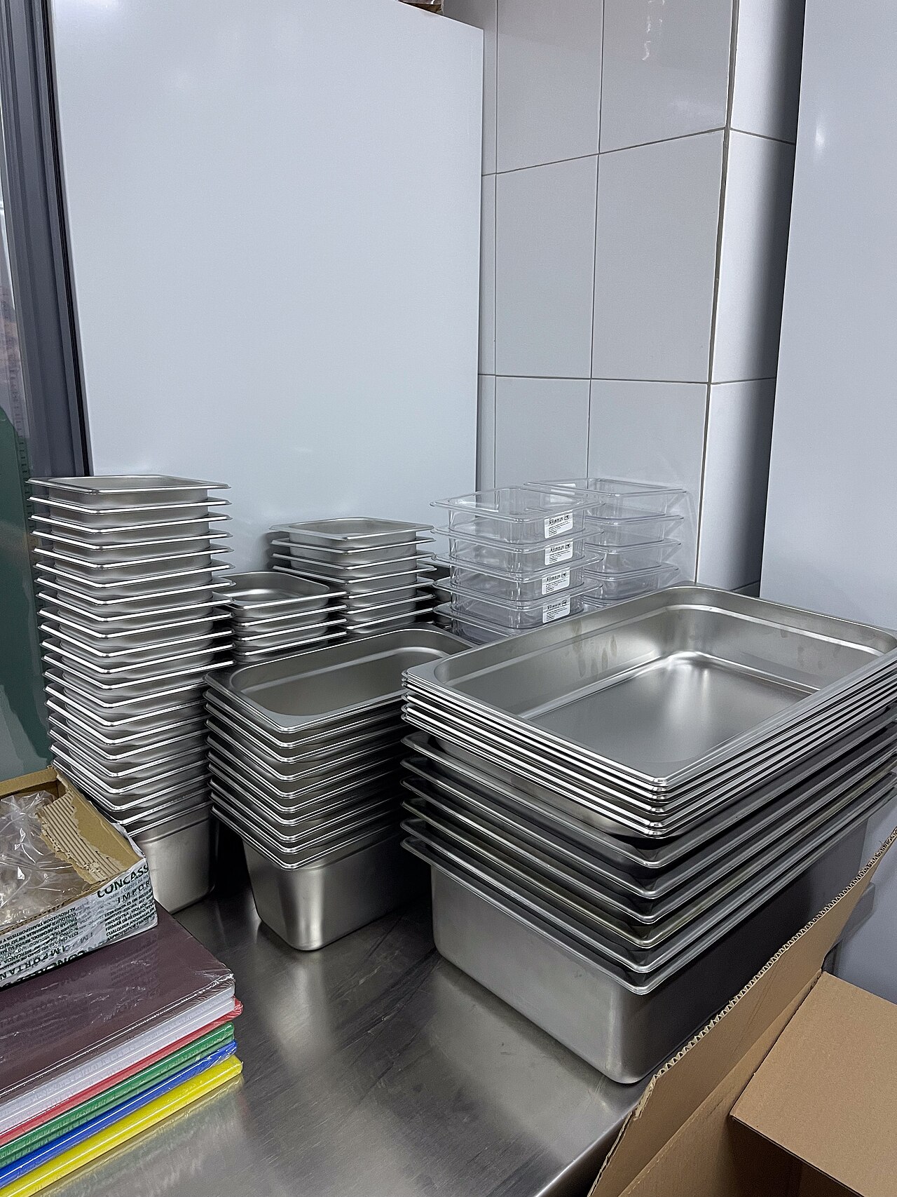Bacinelle Gastronorm in acciaio inox impilate su un piano di lavoro